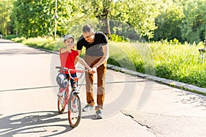 happy father rejoices that her daughter learned to ride a bike