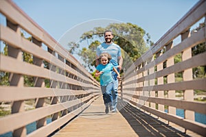 happy father running with his son outside, fun