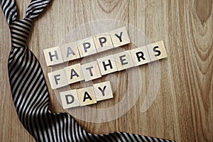 Happy Father`s Day alphabet letters with necktie gift box and red heart fluffy on wooden background