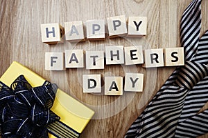 Happy Father`s Day alphabet letters with necktie and gift box on wooden background