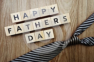 Happy Father`s Day alphabet letters with necktie and gift box on wooden background