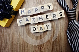 Happy Father`s Day alphabet letters with necktie and gift box on wooden background