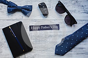 Happy Father`s Day background. Cufflink, car key, bow tie, pen, sunglasses and blue heart.