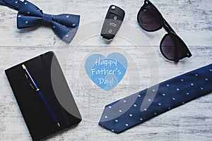 Happy Father`s Day background. Cufflink, car key, bow tie, pen, sunglasses and blue heart.