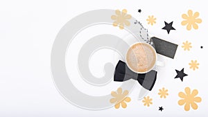 Happy Father`s Day Background. Cup of coffee and black bow tie on white background flat lay. Floral Fathers day still life.