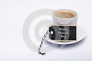 Happy Father`s Day Background. Cup of coffee on white background with gift tag.