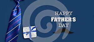 Happy father`s day background. The inscription on a dark background with a gift and tie. Congratulatory background