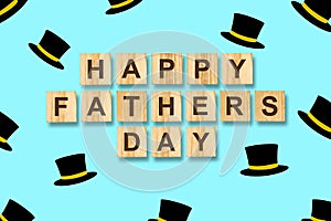 Happy father`s day background. Many cylinder hats on a blue background. Inscribed on wooden blocks. Congratulatory
