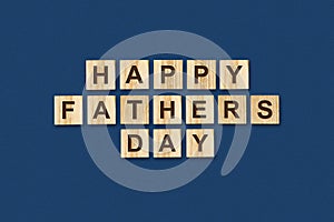 Happy father`s day background. Word written on wooden blocks. Dark background Congratulatory background