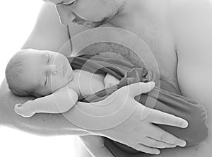 Happy father`s day! Black and white portrait a newborn baby in dadâ€™s arms is sleeping