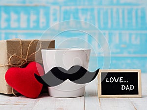 Happy father`s day concept. Gift box, a cup of coffee with must