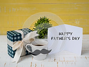 Happy father`s day concept. gift box, a cup of coffee with musta