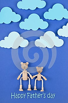 Happy Father`s Day concept. Greeting card with family of wooden toy bears on blue background.