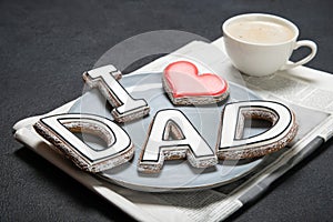 Happy Father`s Day concept. Tasty cookies and cup of coffee on wooden background