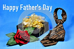 Happy father`s Day-a conceptual inscription of the greeting text. Gift, red rose, tie. The annual honorary Fiesta in honor of the