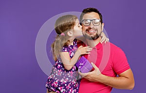 Happy father`s day! cute dad and daughter hugging on violet back