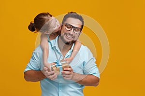 Happy father`s day! cute dad and daughter hugging on yellow back