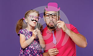 Happy father`s day! funny dad and daughter with mustache fooling