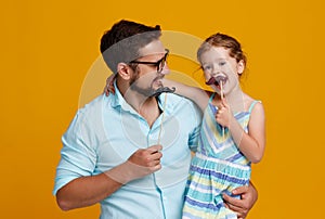 Happy father`s day! funny dad and daughter with mustache fooling