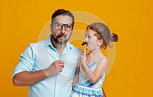 Happy father`s day! funny dad and daughter with mustache fooling