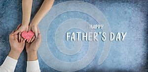 Happy father`s day.Heart in the hands of daughter and father on a blue background.I love you, dad.Love and health in the family.