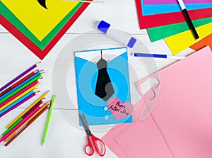 Happy Father`s day.I love dad. Making greeting card. Child draws a black tie and blue shirt. DIY concept. Step-by-step photo