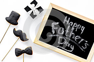 Happy Father`s day cards. Black tie, mustache and hat cookies and gift. White desk background top view