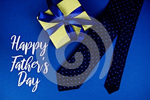 Happy Father\'s Day text with neck tie and gift box Happy Father\'s Day concept on navy background photo