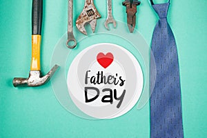 Happy Father`s Day text with old rusty tools and ties on green paper background
