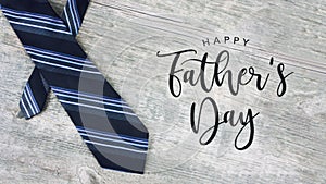Happy Father`s Day Text with Striped Tie Over Wood Background