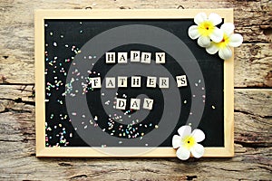 Happy father`s day word from wooden block place on black chalk board