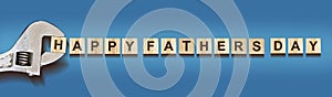 Happy Father`s Day, words on wooden blocks. Wrench. On a blue background. Festive banner. Holidays