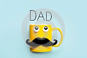 Happy Father`s Day.Yellow mug with mustache and funny eyes looking up with the text Dad