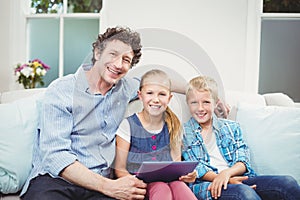 Happy father sitting with children on sofa