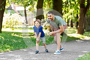 Happy father and son compete in running at park