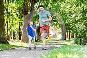 Happy father and son compete in running at park