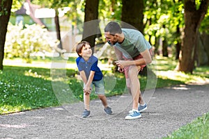 Happy father and son compete in running at park