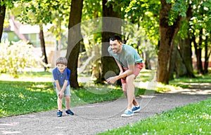 Happy father and son compete in running at park