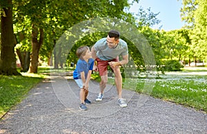 Happy father and son compete in running at park