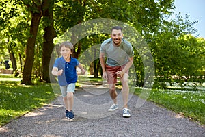 Happy father and son compete in running at park