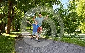 Happy father and son compete in running at park