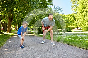 Happy father and son compete in running at park