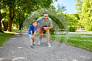 Happy father and son compete in running at park