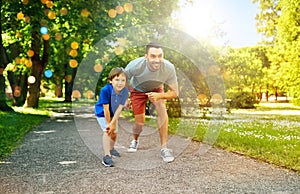 happy father and son compete in running at park