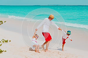 happy father with son and daughter play on beach