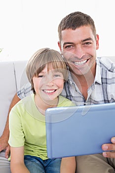 Happy father and son with digital tablet