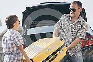 Happy father and son getting ready for road trip on a sunny day