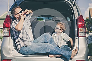 Happy father and son getting ready for road trip on a sunny day