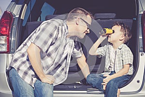 Happy father and son getting ready for road trip on a sunny day