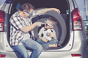 Happy father and son getting ready for road trip on a sunny day